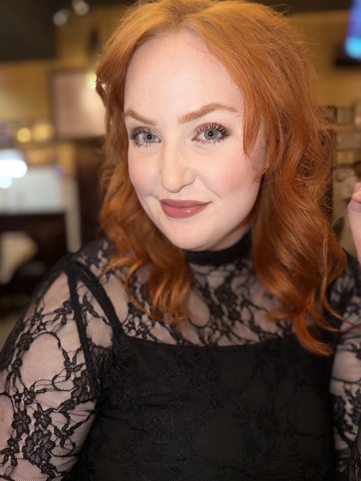 Jess Latham in a black lace top, photographed indoors